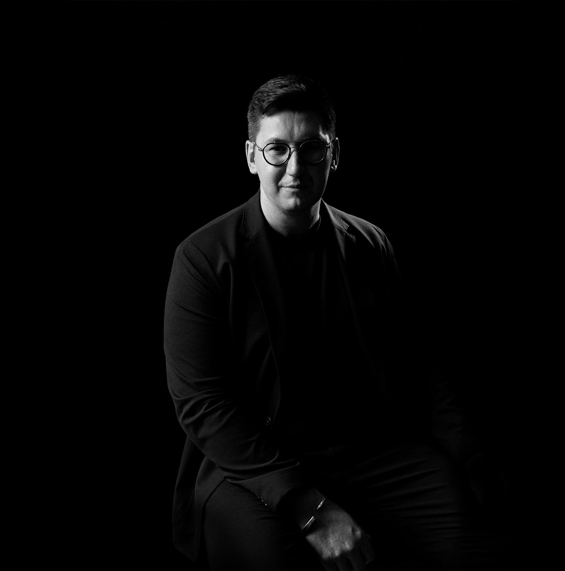 Black and white portrait of Giacomo Ciufoli wearing glasses against a dark background