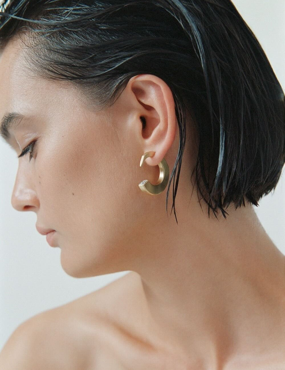 Ciufoli One sculptural medium yellow gold earrings with diamond on model