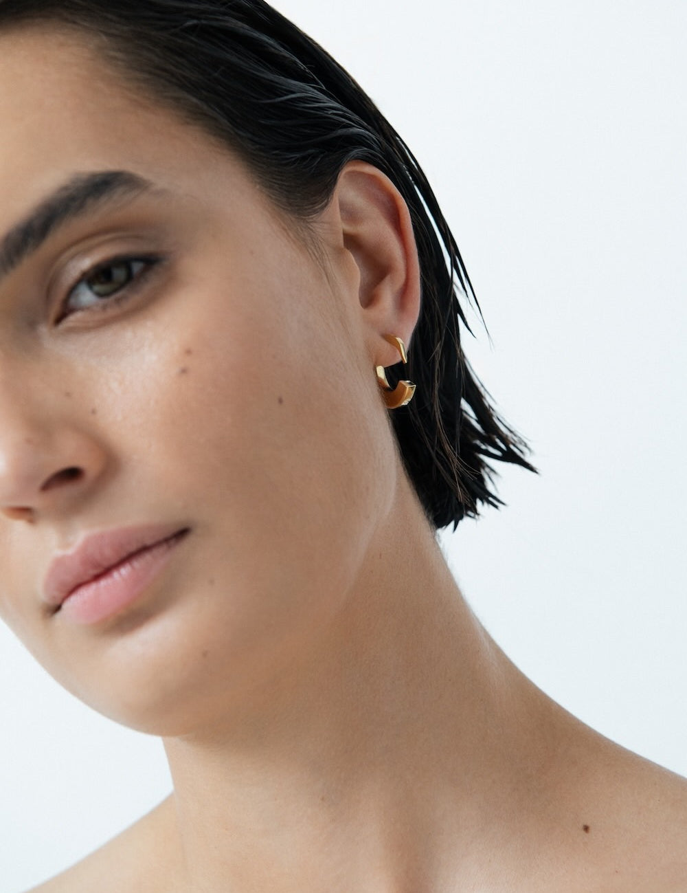 Ciufoli One sculptural small yellow gold earrings on model 