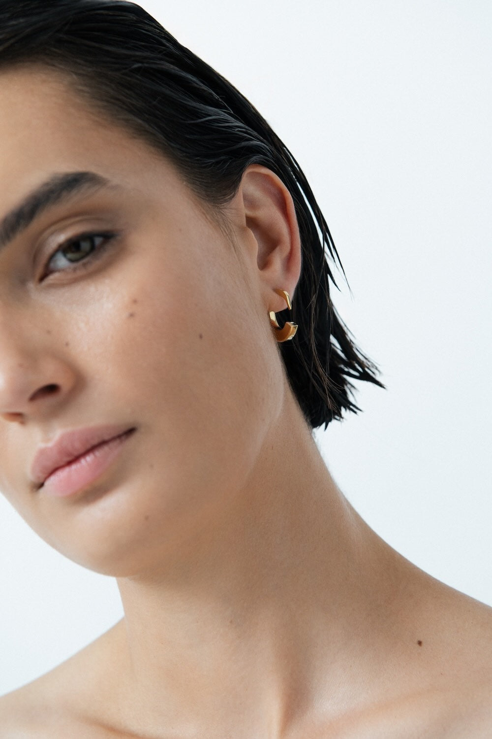 Ciufoli One sculptural small yellow gold earrings on model 